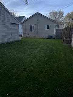 view of side of home with cooling unit and a lawn