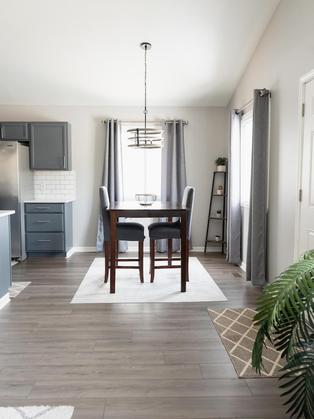 dining area with lofted ceiling and dark wood-type flooring