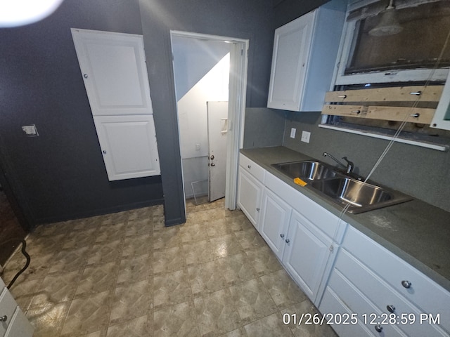 kitchen featuring sink, decorative backsplash, and white cabinets