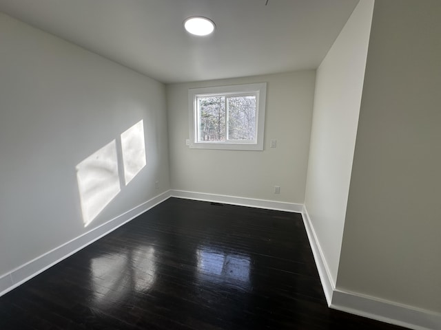 empty room with dark hardwood / wood-style flooring