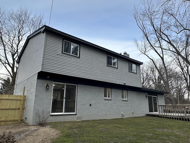 rear view of property with a yard and a deck