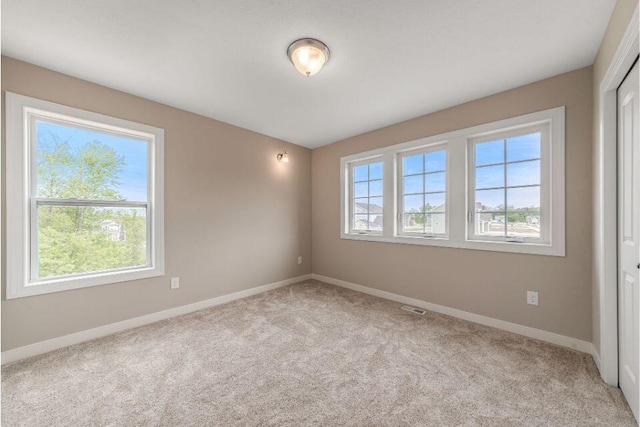 carpeted spare room featuring a healthy amount of sunlight