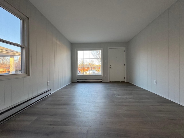 unfurnished room featuring a baseboard radiator and dark hardwood / wood-style floors