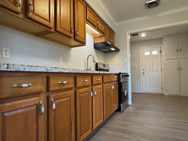 kitchen featuring sink, crown molding, light stone counters, stainless steel range oven, and light wood-type flooring