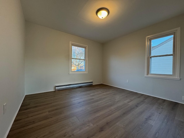 unfurnished room featuring baseboard heating and dark hardwood / wood-style flooring