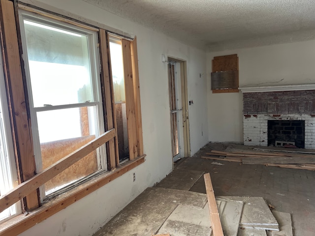 living room with a fireplace and a textured ceiling