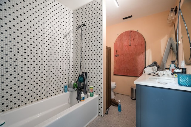 full bathroom with tiled shower / bath, vanity, and toilet