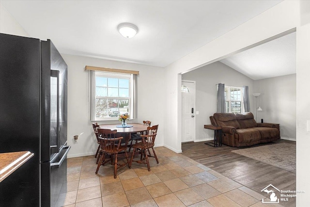 dining room with lofted ceiling, light hardwood / wood-style flooring, and a wealth of natural light