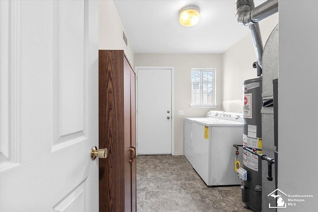 laundry room with washing machine and clothes dryer and water heater