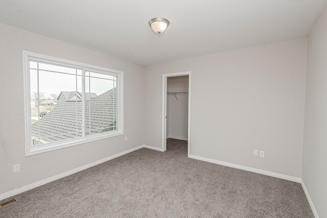 53188 Woodland Mdws, Chesterfield, MI 48047 - unfurnished bedroom with carpet flooring, visible vents, baseboards, a closet, and a walk in closet