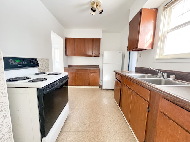 kitchen featuring sink, electric range, and white fridge