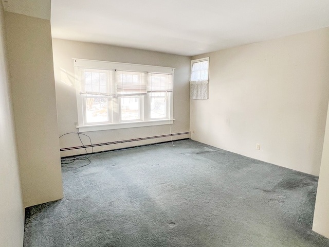 carpeted empty room featuring baseboard heating and a wealth of natural light