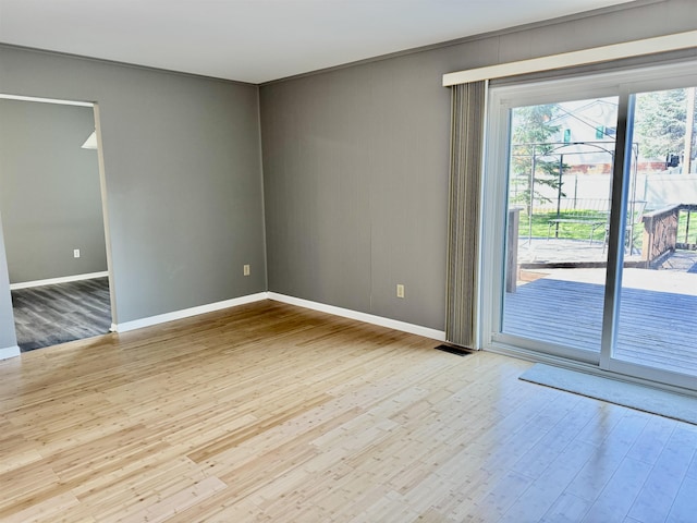 unfurnished room with baseboards and wood finished floors