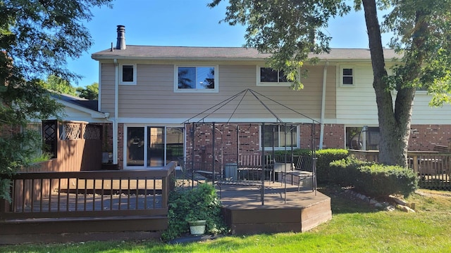 back of property with a wooden deck and a gazebo