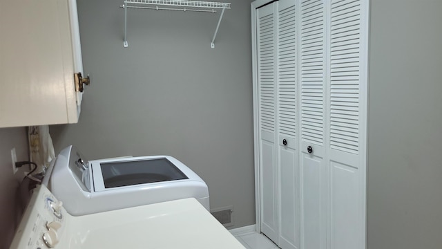 washroom with washing machine and clothes dryer and cabinet space