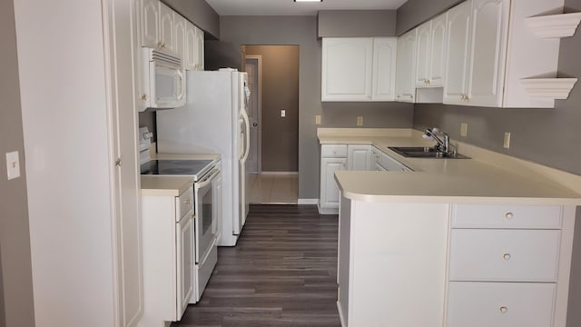 kitchen with sink, white appliances, kitchen peninsula, and white cabinets