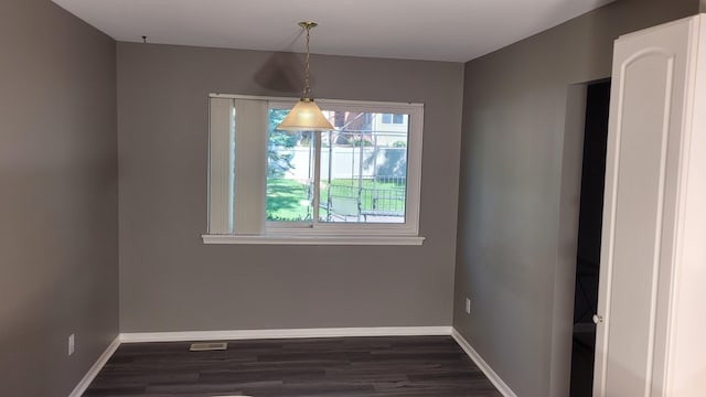 unfurnished dining area featuring dark hardwood / wood-style flooring