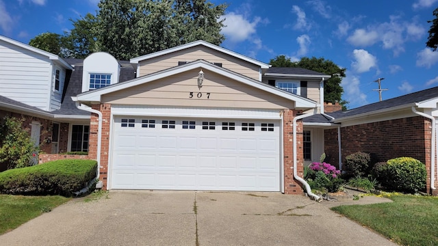 traditional-style home featuring brick siding, concrete driveway, and a garage
