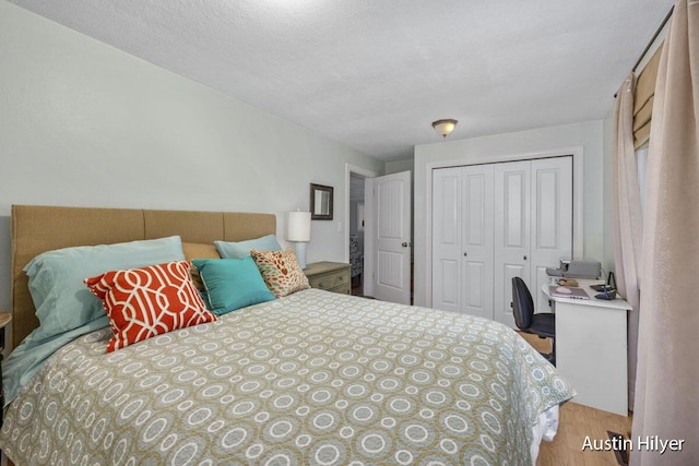 bedroom with light hardwood / wood-style floors, a closet, and a textured ceiling