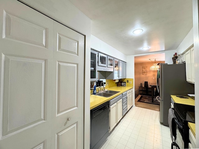 kitchen featuring sink, black appliances, and white cabinets