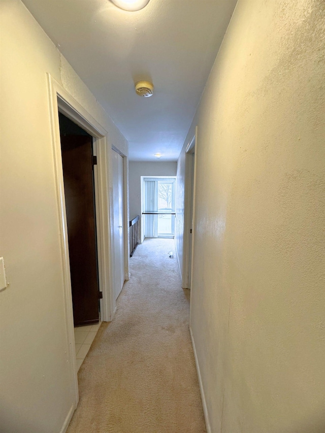 hallway featuring light colored carpet