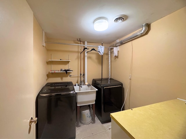 clothes washing area featuring separate washer and dryer, sink, and light tile patterned floors