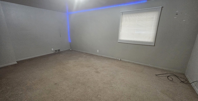 unfurnished room featuring light carpet