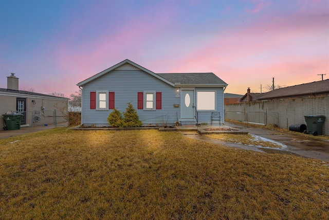 back house at dusk featuring a yard