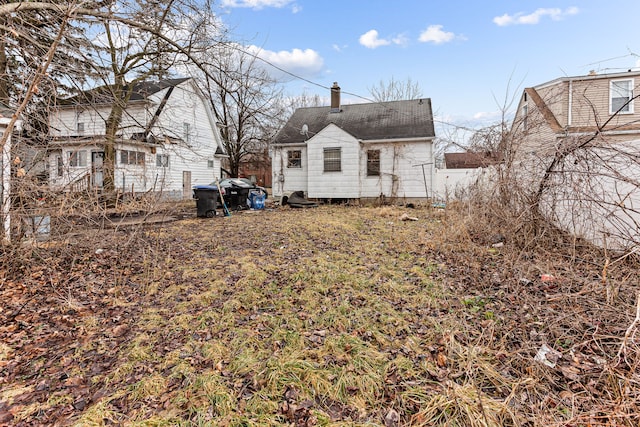 back of house with a chimney