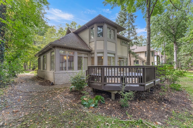 rear view of property featuring a wooden deck