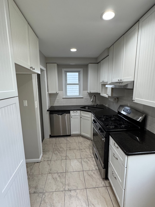 kitchen featuring stainless steel appliances, sink, decorative backsplash, and white cabinets