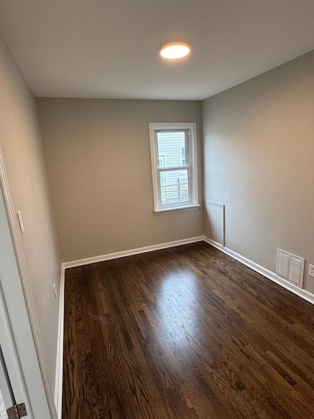 spare room featuring dark wood-type flooring