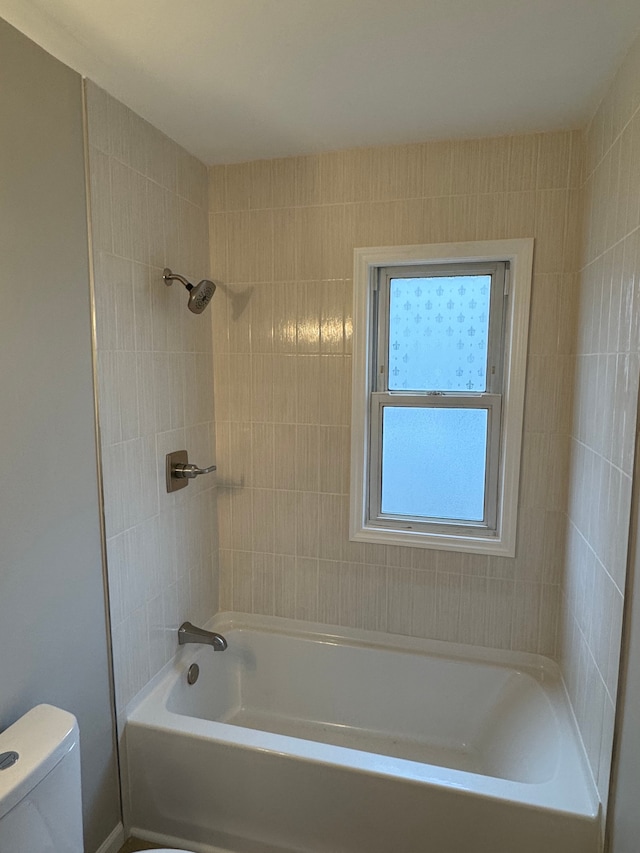 bathroom with tiled shower / bath and toilet