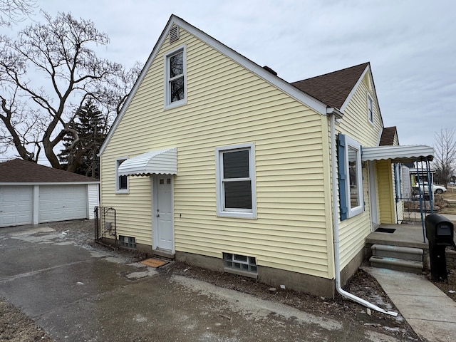 back of property featuring a garage and an outdoor structure