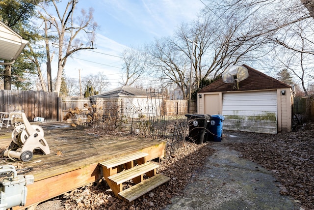 view of yard with a garage, an outbuilding, and a wooden deck