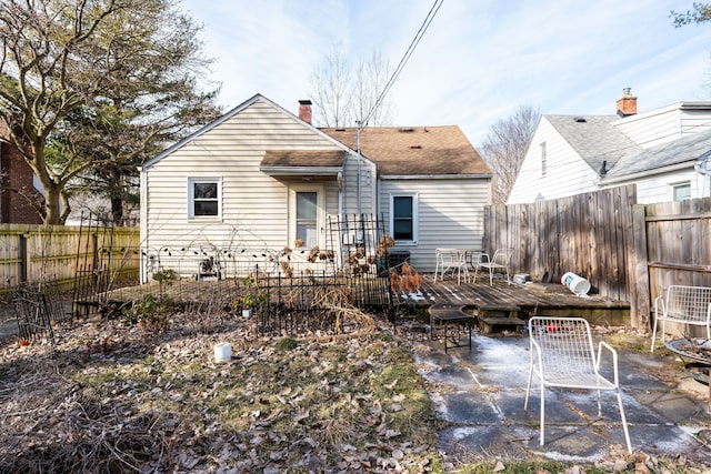 back of house featuring a wooden deck and a patio area