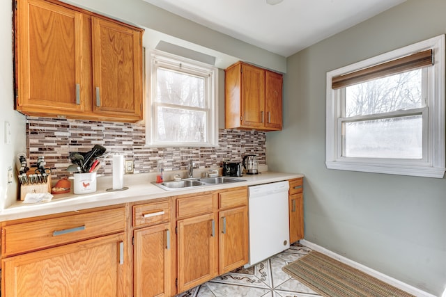 kitchen with decorative backsplash, dishwasher, light tile patterned floors, and sink