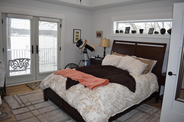 bedroom featuring access to exterior, hardwood / wood-style flooring, and french doors