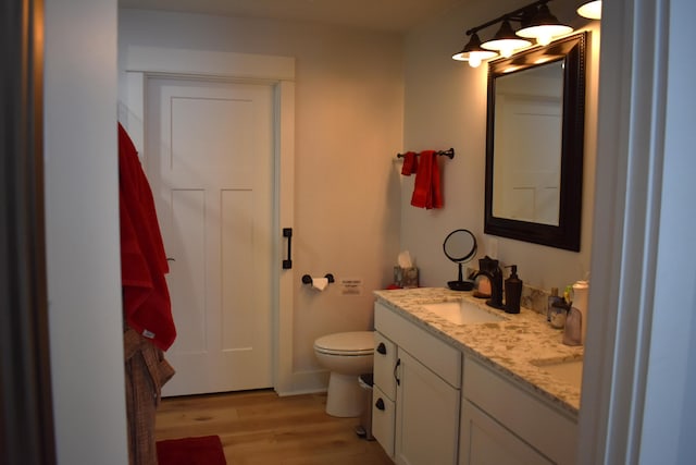 bathroom with vanity, toilet, and hardwood / wood-style floors