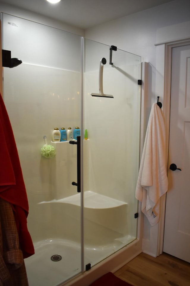 bathroom featuring wood-type flooring and a shower with door