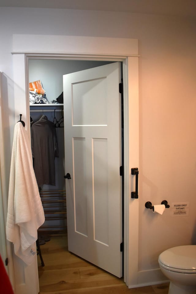 bathroom with hardwood / wood-style floors and toilet