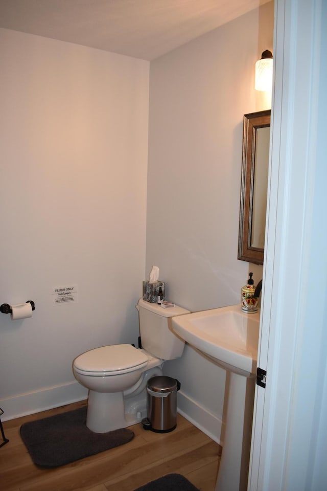 bathroom featuring wood-type flooring and toilet