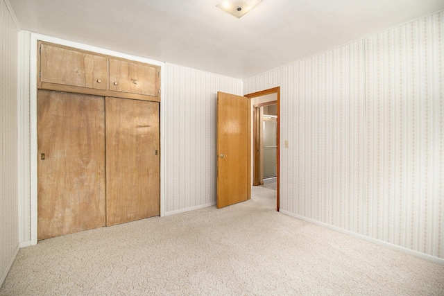 unfurnished bedroom with light carpet and a closet