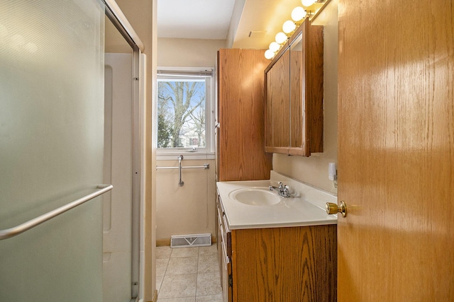 bathroom with an enclosed shower, vanity, and tile patterned floors