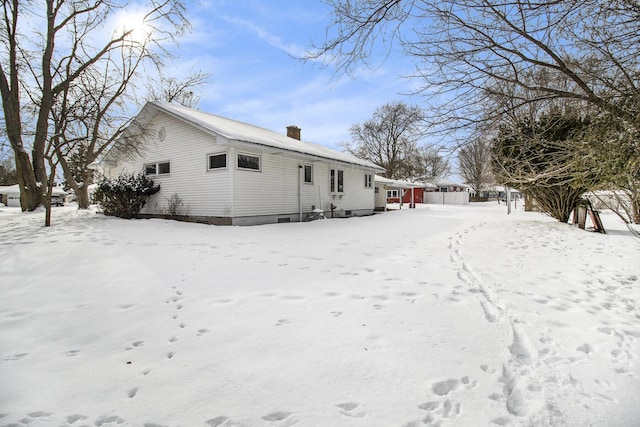 view of snow covered back of property