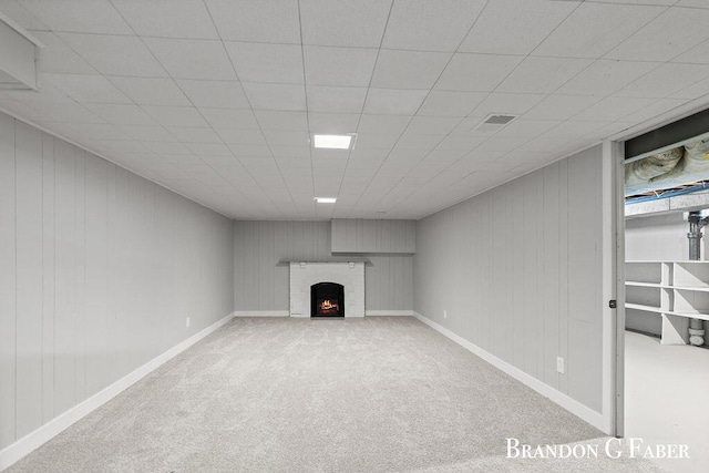 basement with light carpet and a fireplace