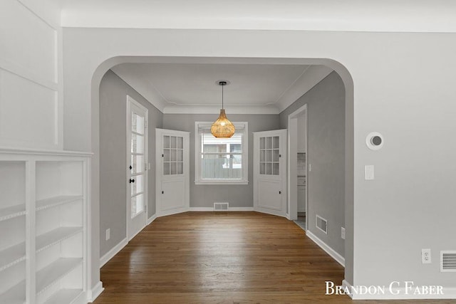 foyer featuring ornamental molding and dark hardwood / wood-style flooring