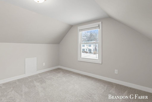 additional living space featuring lofted ceiling and carpet