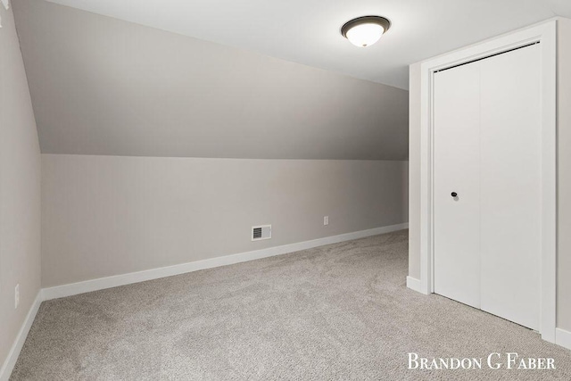 bonus room featuring lofted ceiling and light carpet