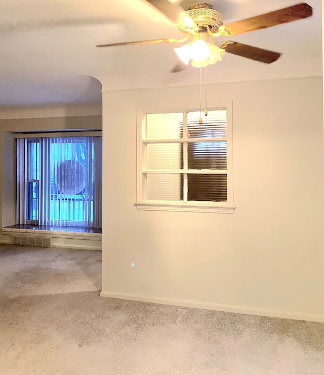 unfurnished room with ceiling fan and carpet